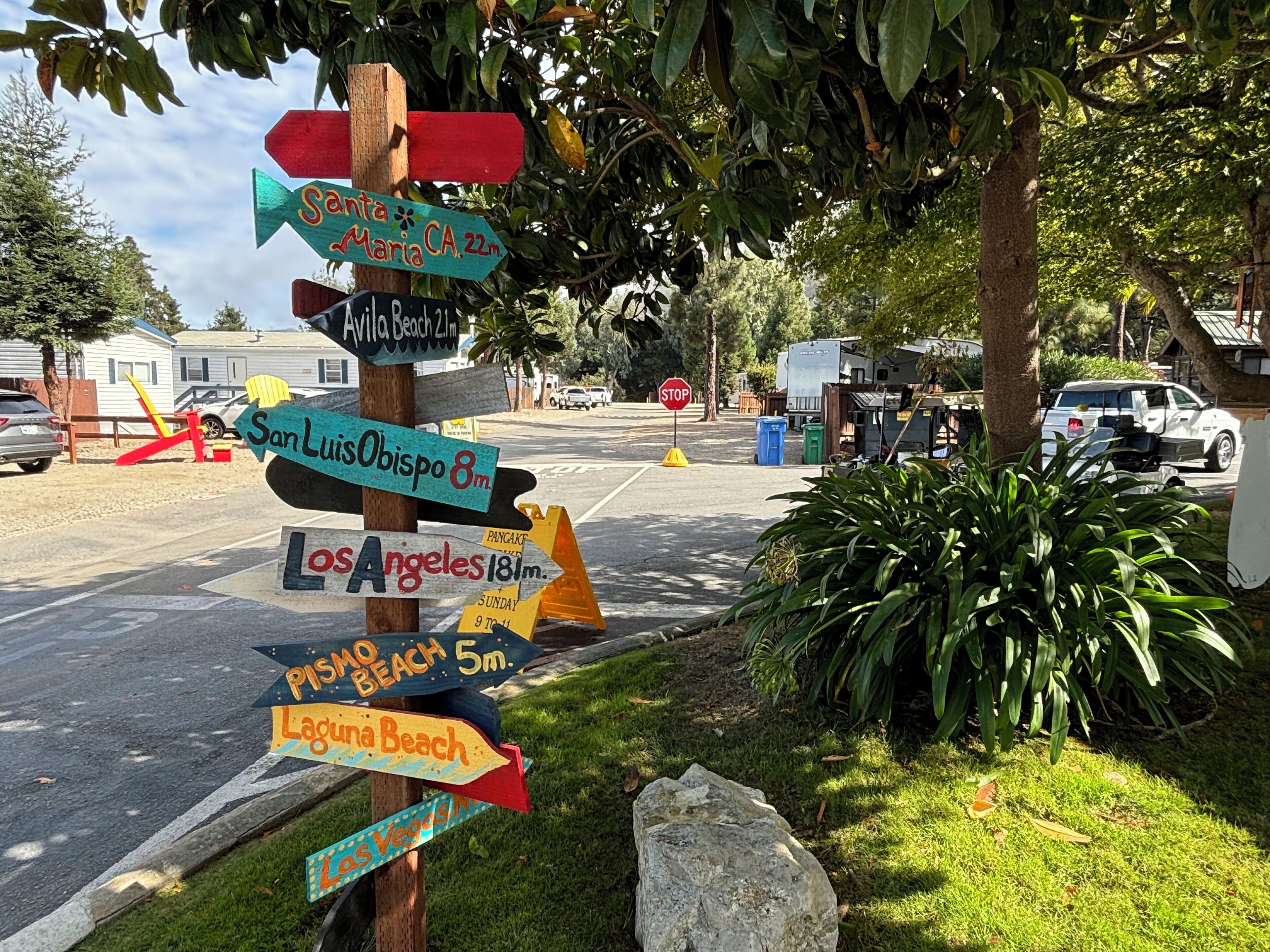 A wooden signpost with directional arrows pointing to various destinations.