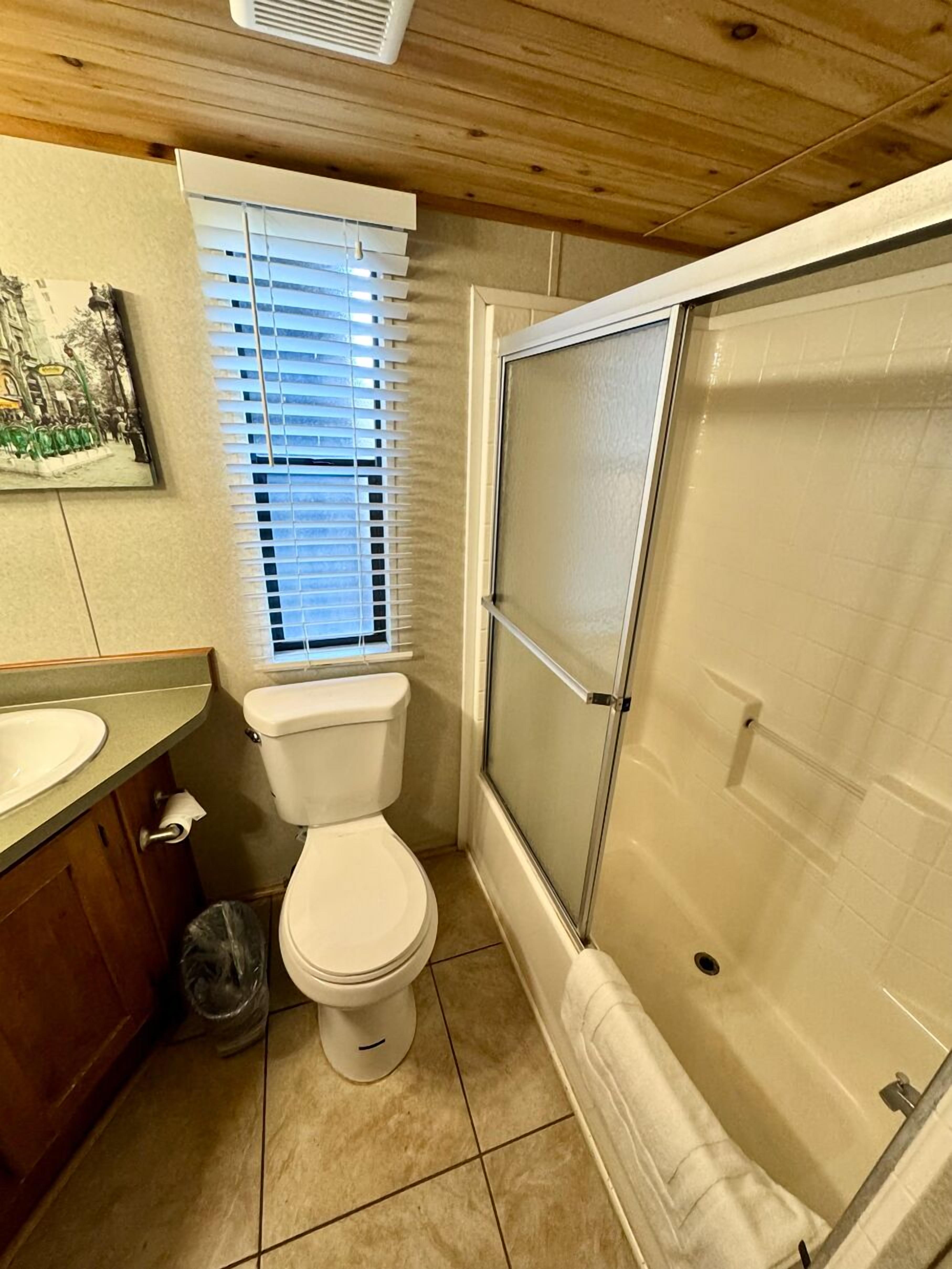 Une petite salle de bain comprenant des toilettes, un lavabo et une douche.