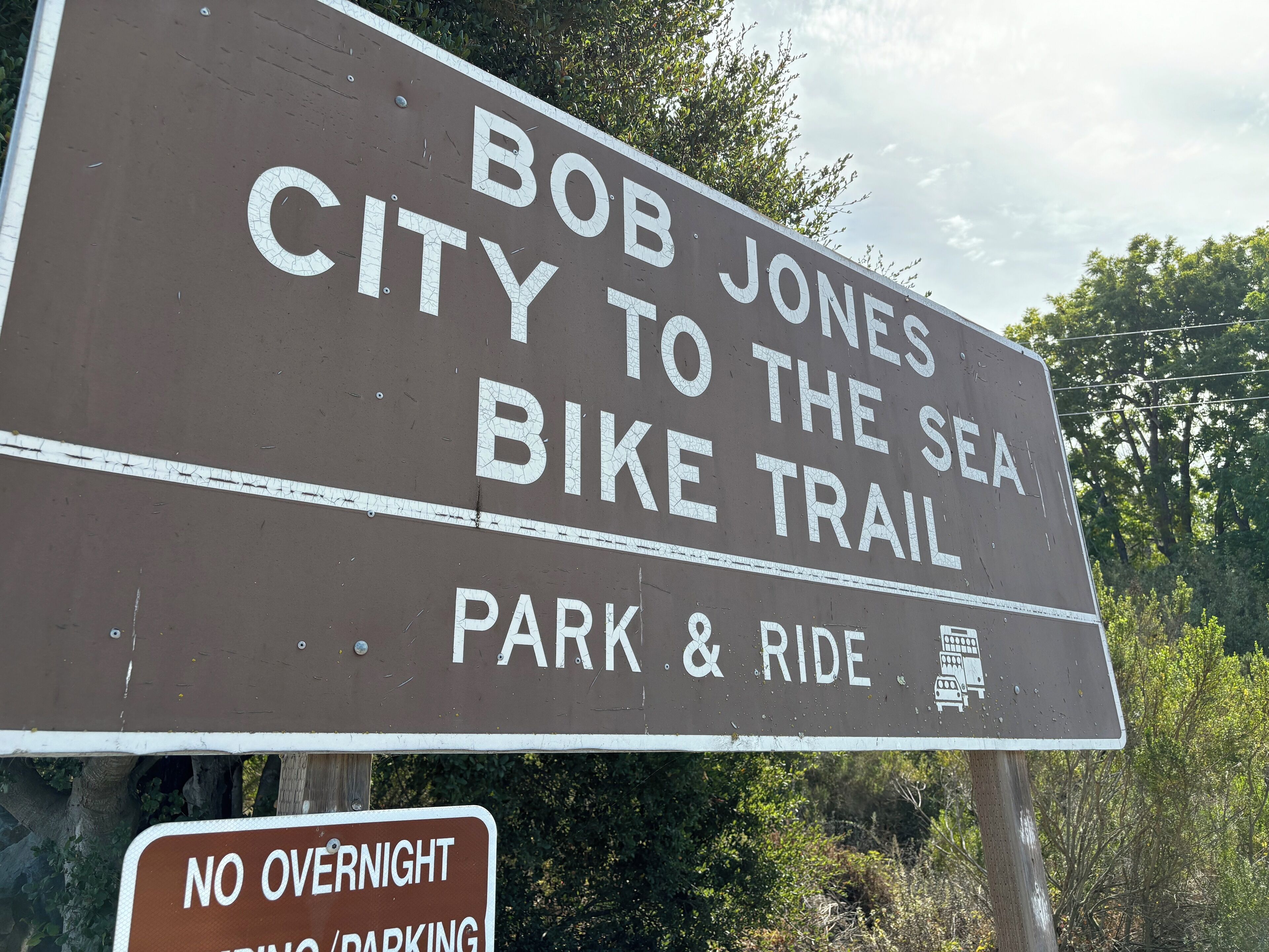 Schild für den Bob Jones City to the Sea Bike Trail mit einem darunter angebrachten 'Kein Übernachtparken'-Schild.
