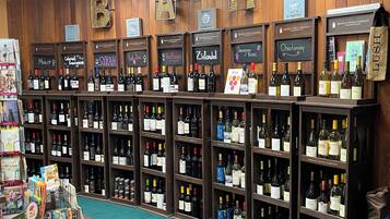 A wine store with wooden shelves and signs indicating different wine brands and types.