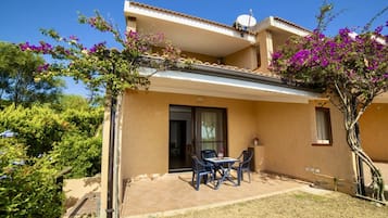 Un bâtiment à deux étages doté d’un balcon, d’un espace extérieur aménagé pour s’asseoir et d’un jardin.