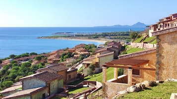 Un village côtier aux maisons traditionnelles en pierre, doté d’une plage et bordé de montagnes.