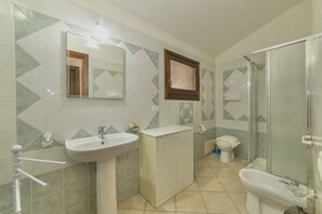 A bathroom with a sink, mirror, cabinet, toilet, and shower. - Porto Coral Villa, Sleeps 8 (Villaputzu)
