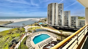 Un hotel moderno con piscina, vista a la playa y un muelle.