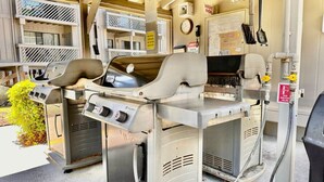 Una cocina comercial con dos parrillas grandes, un extintor de incendios y una llave de corte de gas.