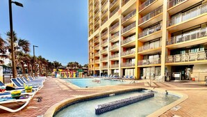 Ein Hotelpoolbereich mit Liegestühlen und einem Whirlpool.