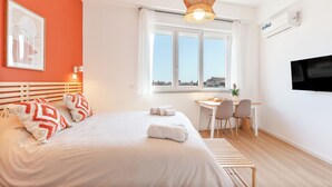 Une chambre d’hôtel moderne, dotée d’un grand lit, d’un bureau et d’une télévision.