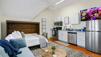 Eine moderne Wohnung mit Schlafzimmer, Küchenzeile und Wohnbereich.