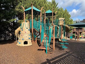 A playground with climbing structures, slides, and a covered play area.