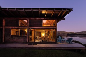Overlooking a serene lake, this cabin features a dining area and a living room.