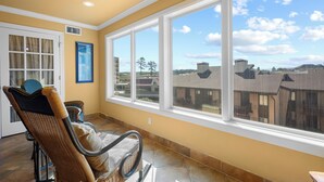 A room with a large window, a wicker chair, and a door. - Condo at Sunbay Resort! Heated Pool & Hot Tub! (Hot Springs)