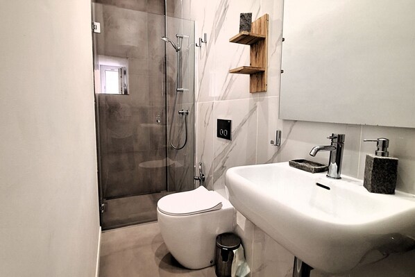 A modern bathroom with a toilet, sink, and shower. - Artemis Moon - Ortigia Lovely Apt (Siracusa)