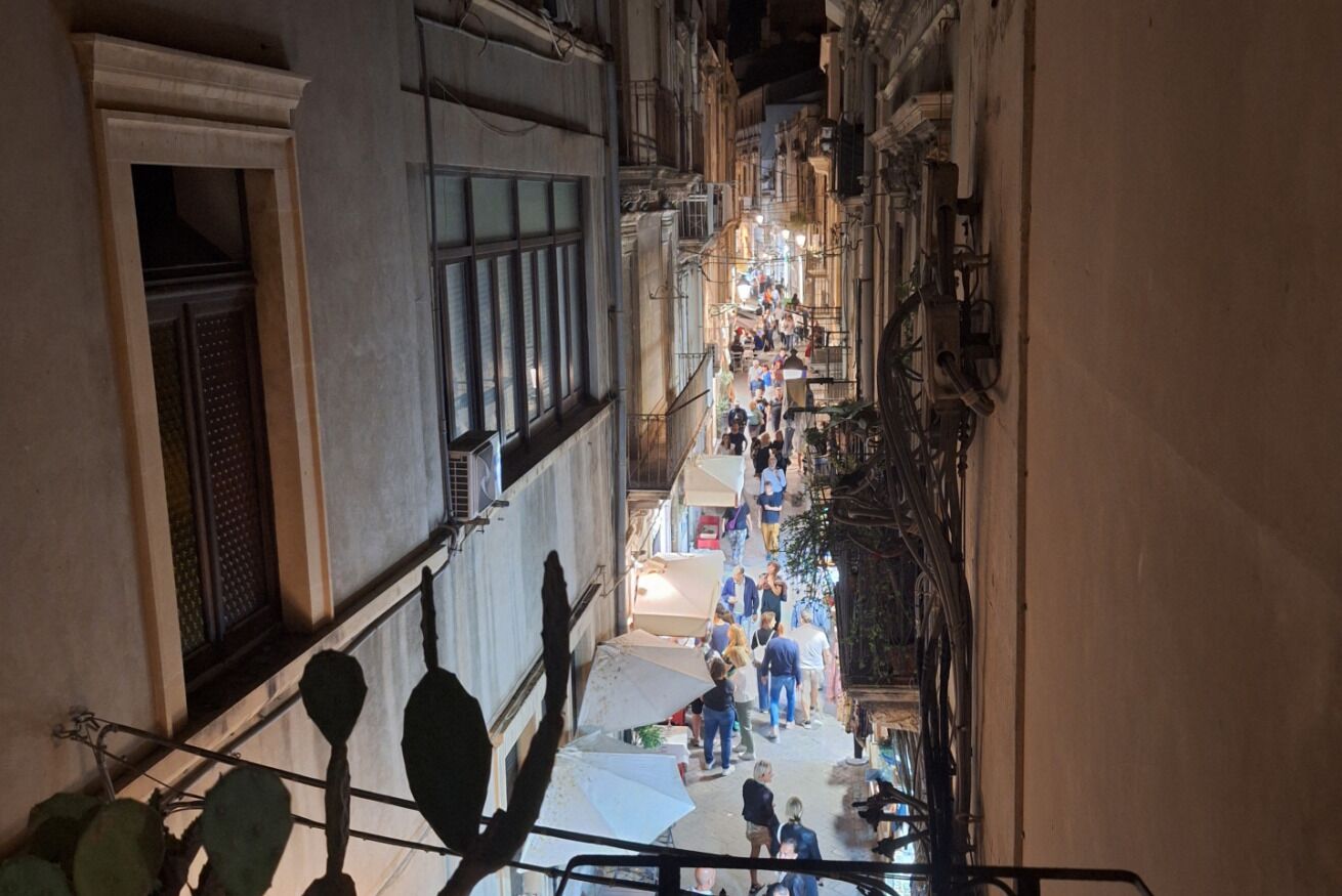 Une ruelle étroite, bordée de boutiques et où l’on peut voir des gens qui se promènent.
