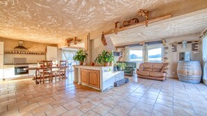 A spacious kitchen with a dining area, wooden cabinets, and a large island. - Holiday Home 'L'Ecurie' with Private Pool, Private Terrace and Wi-Fi (Guizengeard)