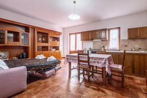 A compact living space with a kitchenette, a dining area, and a bed with a mattress on the floor. - Apartment 'Casa Doriana' with Balcony and Wi-Fi (Poggio Murella)