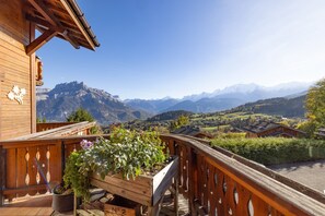 Un edificio de madera con un balcón que da a un paisaje montañoso.