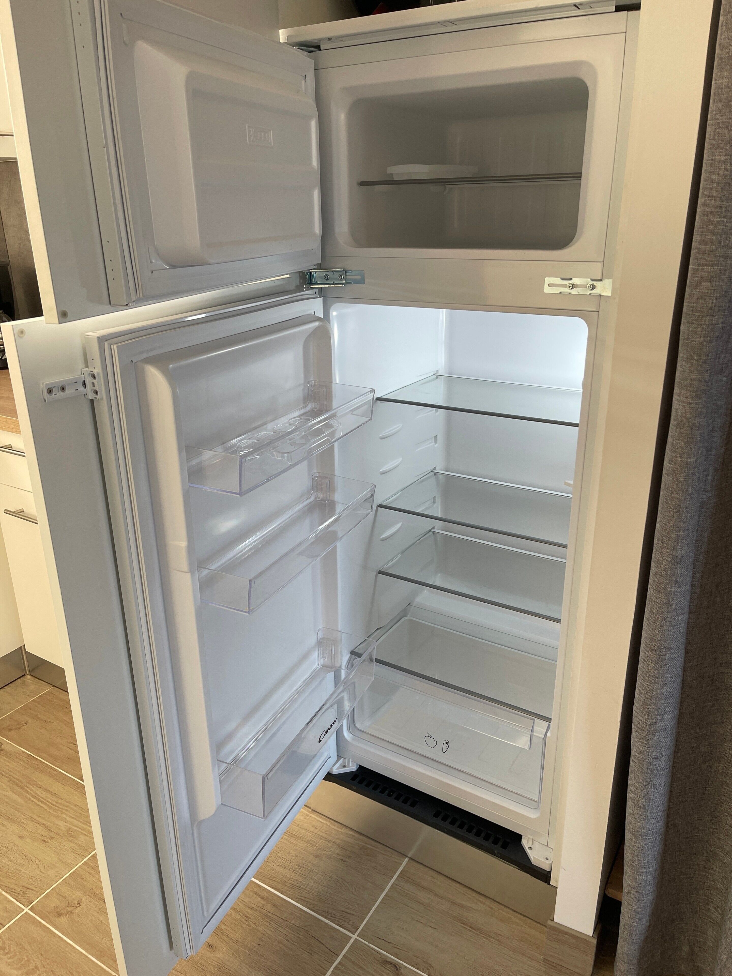 Ein offener Kühlschrank mit mehreren Regalen und einem Gefrierfach.