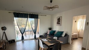 Un espace de vie moderne comprenant un coin repas, un canapé et un balcon.