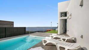 A swimming pool with lounge chairs and a view of the sea. - Brand-New Villa 'Carlota' with Sea Views, Private Pool & Wi-Fi (garachico)