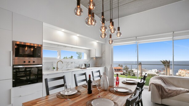 A modern kitchen with a dining area, large windows, and a view of the sea. - Brand-New Villa 'Carlota' with Sea Views, Private Pool & Wi-Fi (garachico)