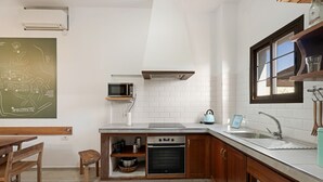 Een keuken met een magnetron, oven en spoelbak.