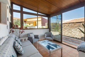 Une pièce lumineuse, avec un canapé, des fauteuils et une table basse.