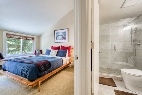 Un dormitorio con una cama grande, una ventana y una zona de ducha.