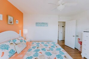 A bedroom with a bed, a ceiling fan, a nightstand, and a lamp. - Coastal Distancing: Oceanside, Private Pool, Hot Tub, Close to Beach (Nags Head)
