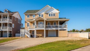 A two-story residential building with a balcony, a garage, and a driveway. - Coastal Distancing: Oceanside, Private Pool, Hot Tub, Close to Beach (Nags Head)