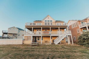 A multi-story building with a balcony, a staircase, and a picnic table in the foreground. - Coastal Distancing: Oceanside, Private Pool, Hot Tub, Close to Beach (Nags Head)