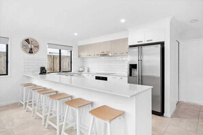 Enjoy cooking in this well-lit kitchen with a large island and stainless steel appliances.