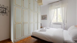 A bedroom with a bed, a wardrobe, a window with curtains, a radiator, and a wall-mounted artwork. - Functional apartment of about 54 square meters, able to accommodate up to 4 people, located on the top or floor of a building with a lift.The property is located in a historic area of the Navigli near the Milanese nightlife, full of restaurants, ba (Milano)