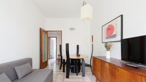 A modern living room with a sofa, dining table, chairs, a TV, and artwork on the wall. - Functional apartment of about 54 square meters, able to accommodate up to 4 people, located on the top or floor of a building with a lift.The property is located in a historic area of the Navigli near the Milanese nightlife, full of restaurants, ba (Milano)