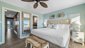 A bedroom with a large bed, a ceiling fan, and a view of the outside. - Sunkissed Sands @ Perdido Dunes | Spacious & Beachfront | Direct Beach Access | My Beach Getaways (Pensacola)