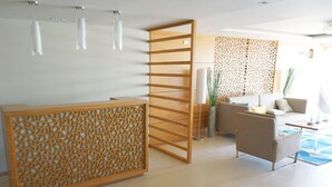 Een moderne receptiebalie met een houten scheidingswand, een bank en een bijzettafeltje.