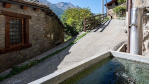 Un bâtiment en pierre doté d’une fenêtre et d’un tuyau en métal.