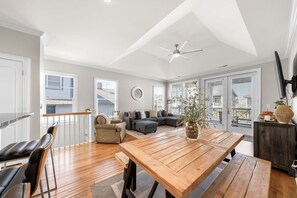 Relax in this inviting living area with a high ceiling, comfortable sofa, and dining table.
