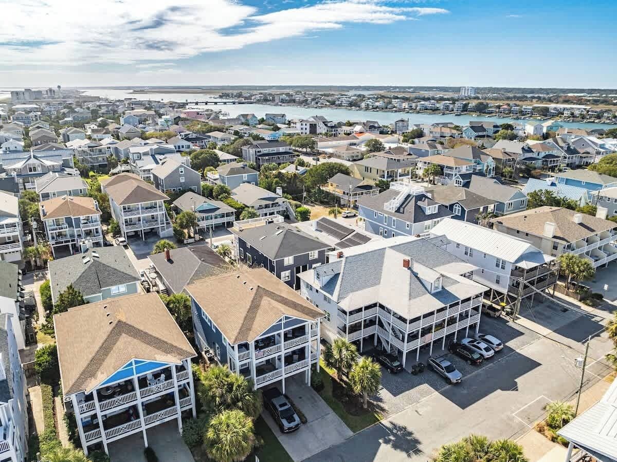 A residential area with houses, a parking lot, and a view of the water.