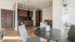 Una cocina moderna con armarios de madera oscura, horno empotrado y cafetera.