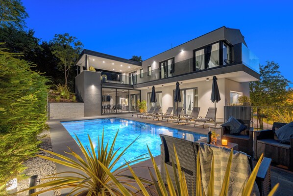 Relax on the spacious balcony or by the outdoor pool, surrounded by a well-maintained garden.