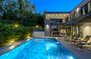 Relax by the pool surrounded by lush gardens and comfortable lounge chairs.