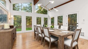 A dining area with a wooden table, chairs, and a chandelier.