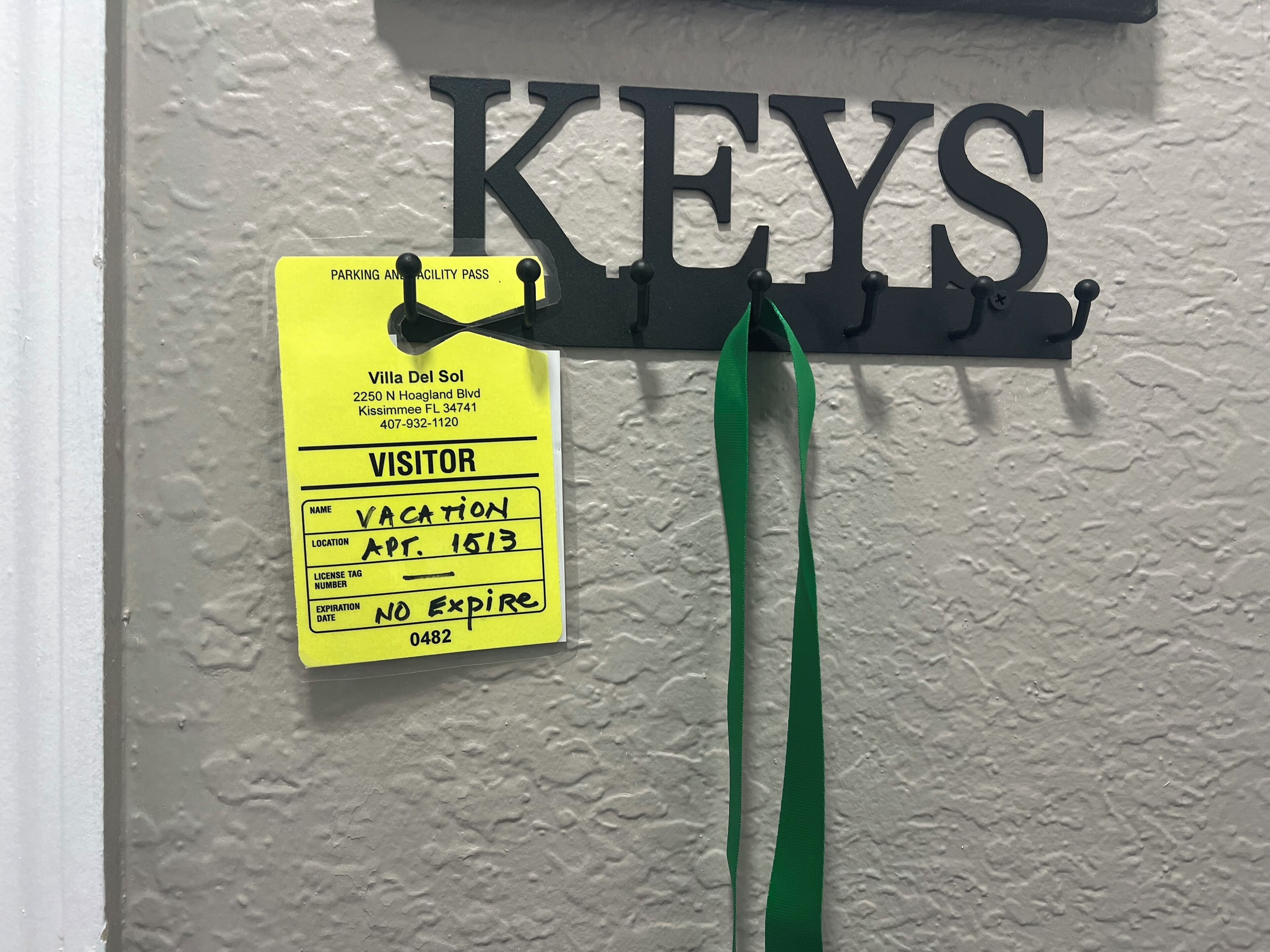 Ein an der Wand befestigtes Schild mit der Aufschrift 'KEYS' und einem gelben Besucherausweis.