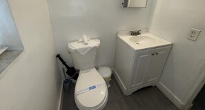 Een haardroger, handdoeken, zeep, toiletpapier