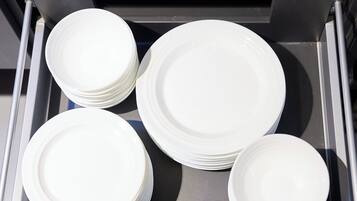 A drawer containing several white plates.