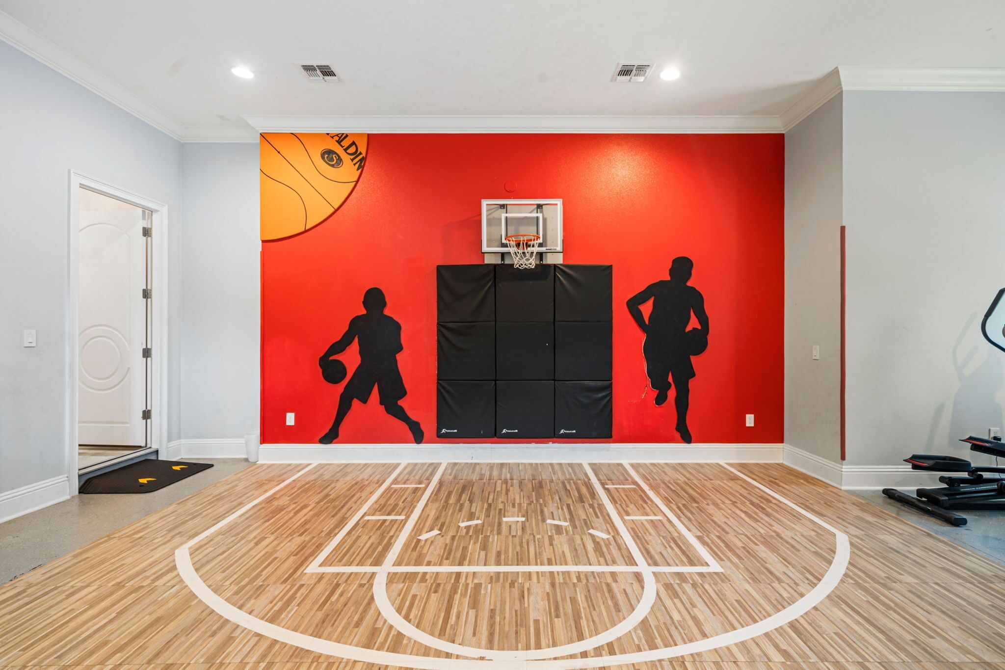 Un terrain de basket avec un mur rouge et un panier de basket.