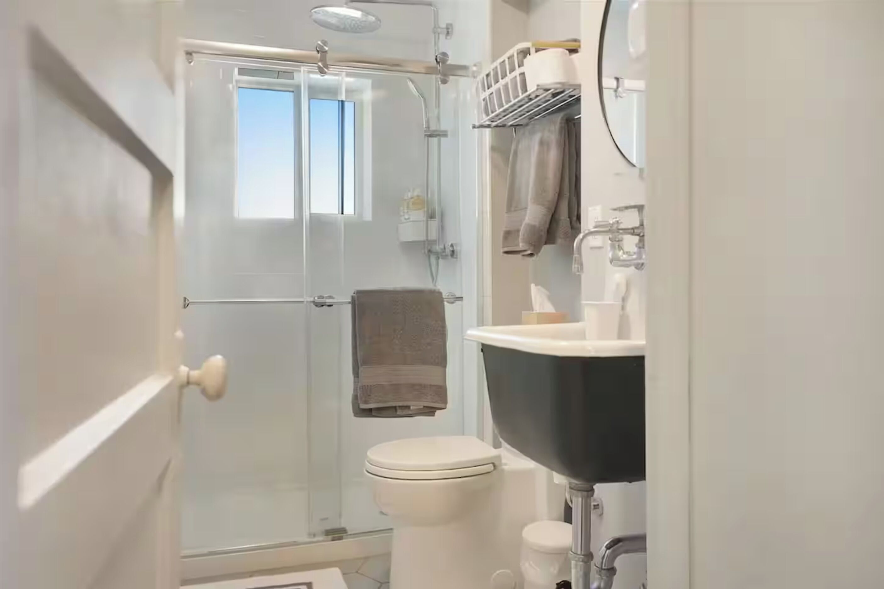 Un baño con ducha de vidrio, inodoro y lavamanos.