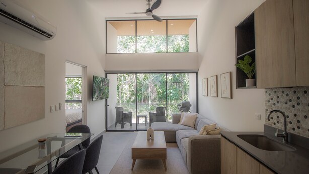 Une cuisine moderne avec un coin repas, de grandes fenêtres et un ventilateur de plafond.