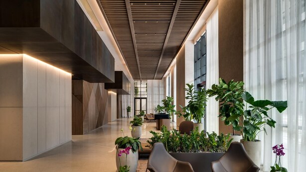 En moderne lobby med en lang gang, siddeområder og store vinduer.
