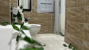Une salle de bain avec des toilettes, un lavabo et un miroir.
